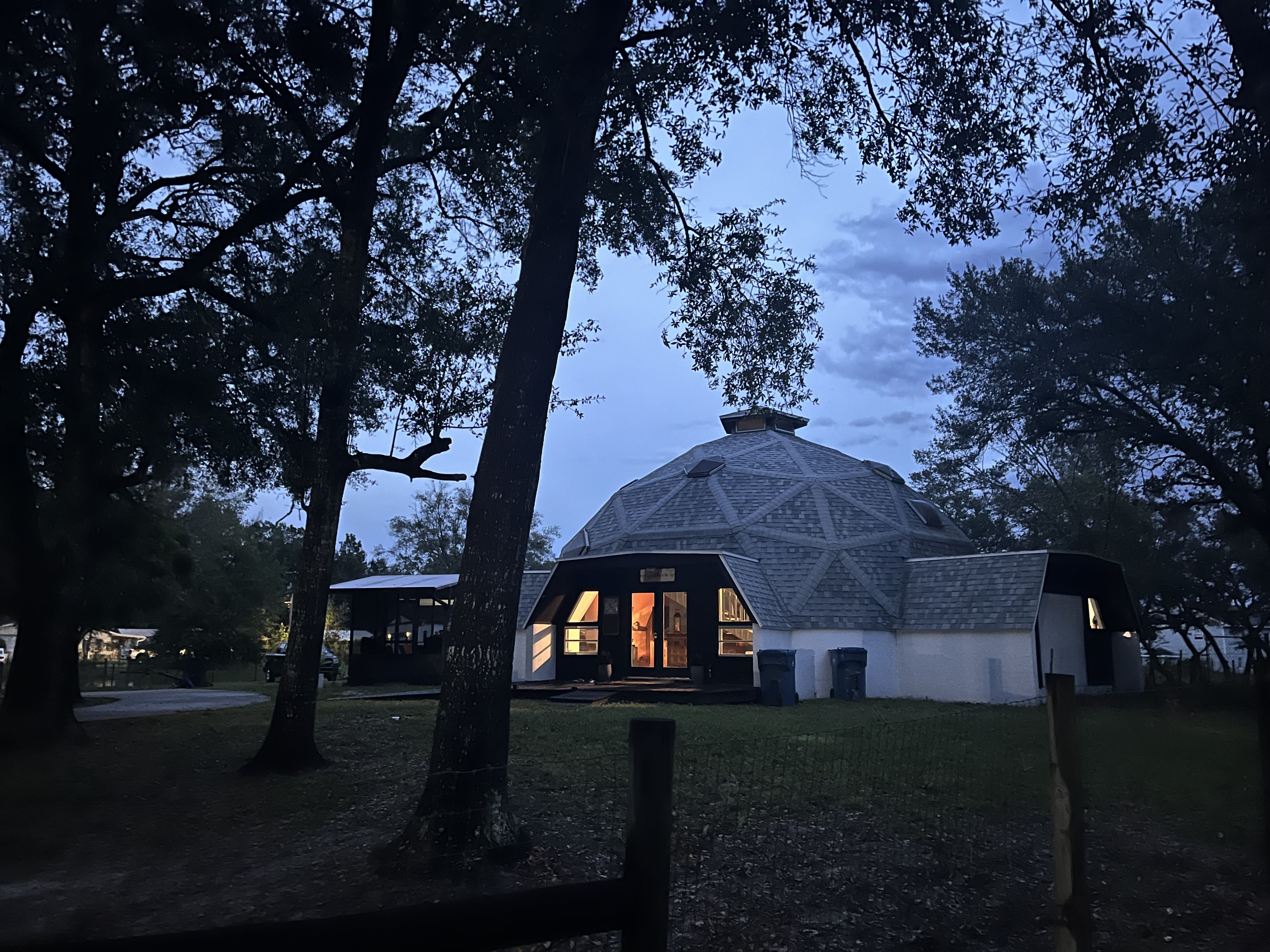 Geodesic Dome Home at twilight with warm interior lighting glowing through windows